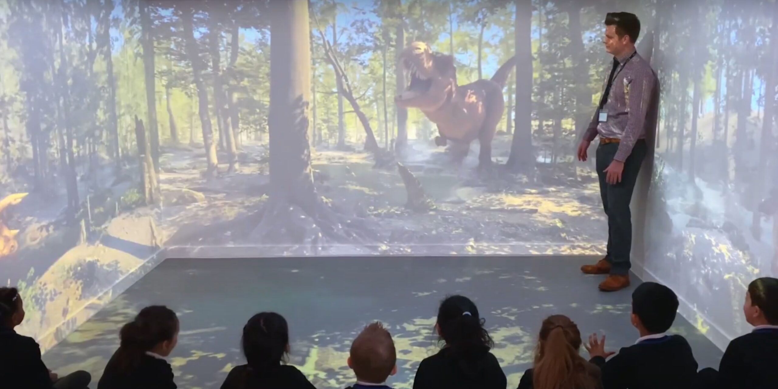 What is the process of installing an immersive classroom? 3 Educator teaching class about dinosaurs